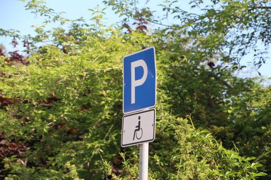 Verkehrsschild weist auf Behindertenparkplatz hin.