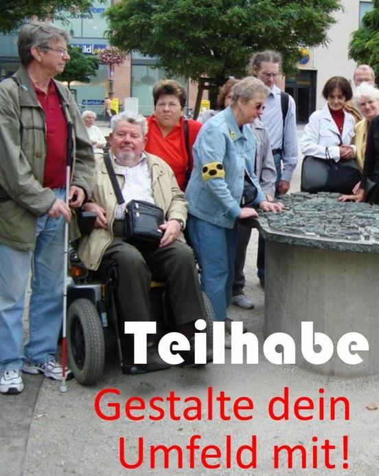 Mit mit Behinderung stehen zusammen. Daneben steht ein kleines Modell von der Stadt Brandenburg an der Havel. Auf dem Bild steht: Teilhabe